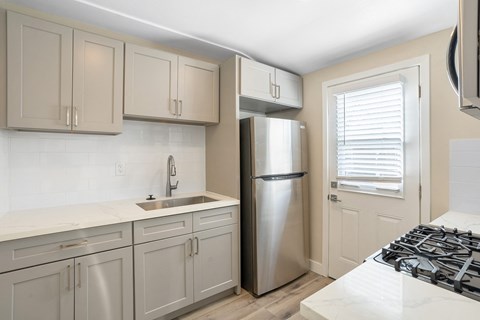 a kitchen with white cabinets and a stainless steel refrigerator